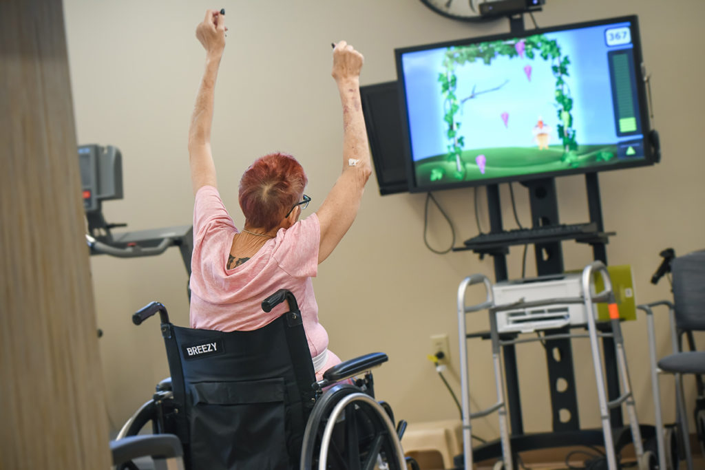 a woman in a wheelchair watching a tv