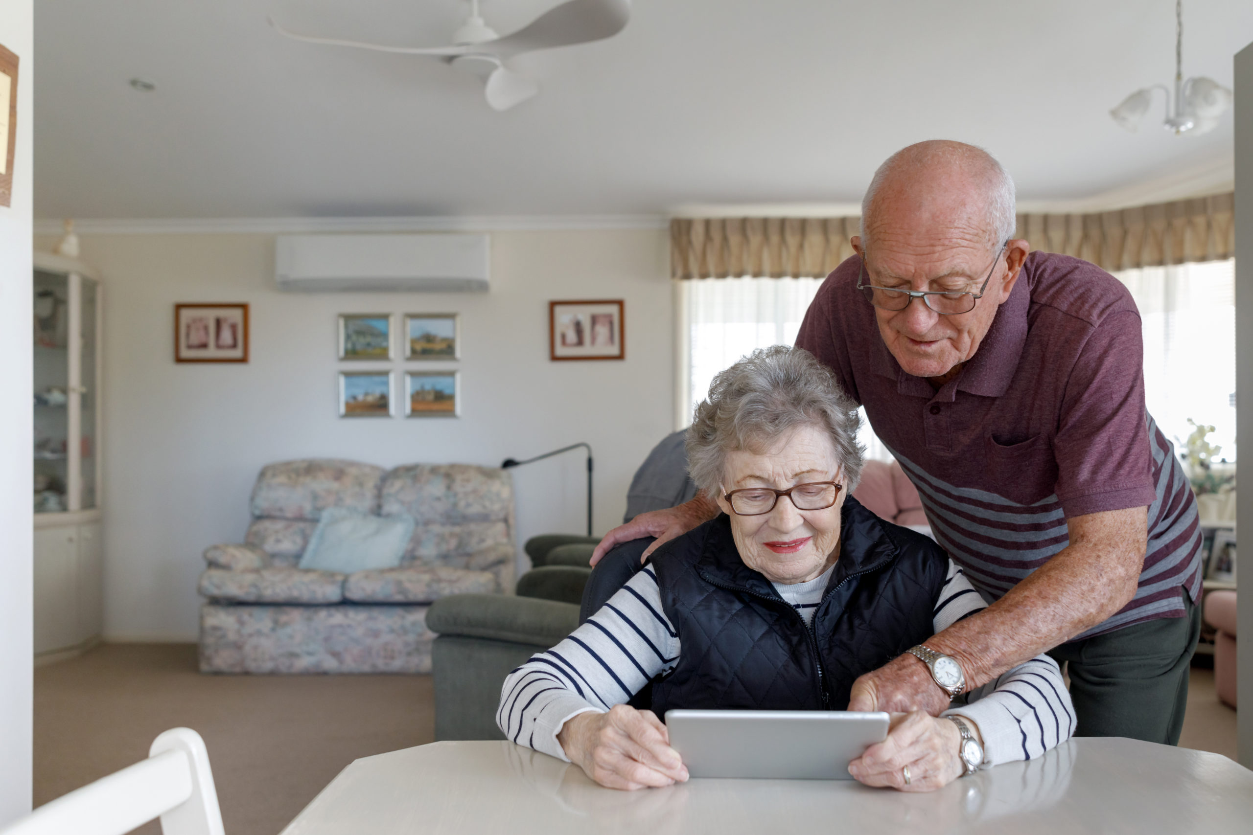 Older couple work on computer at table