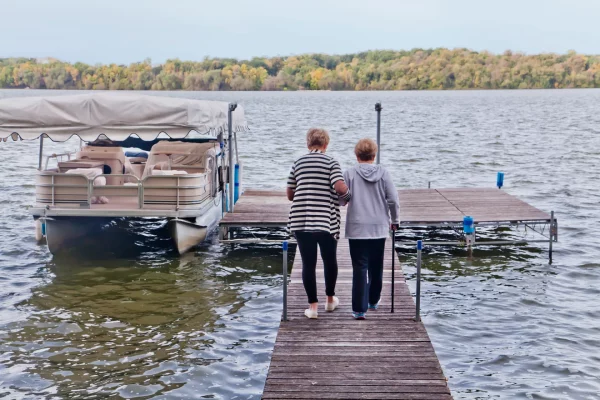 Home Health Aide helping woman walk on the dock